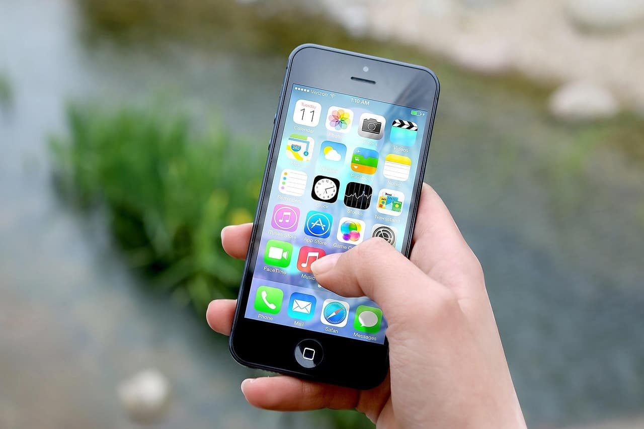 Hand holding a smartphone with app icons