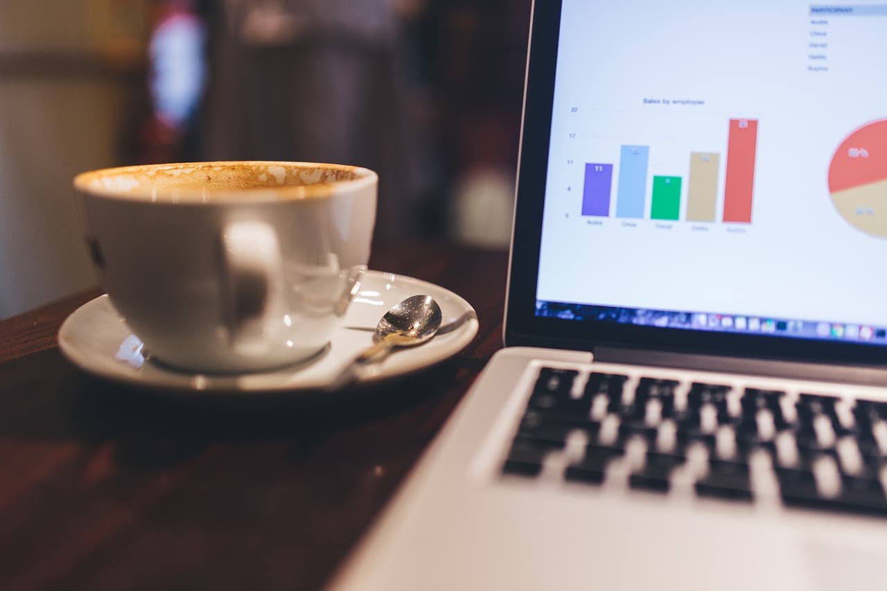 Laptop showing charts on a café table